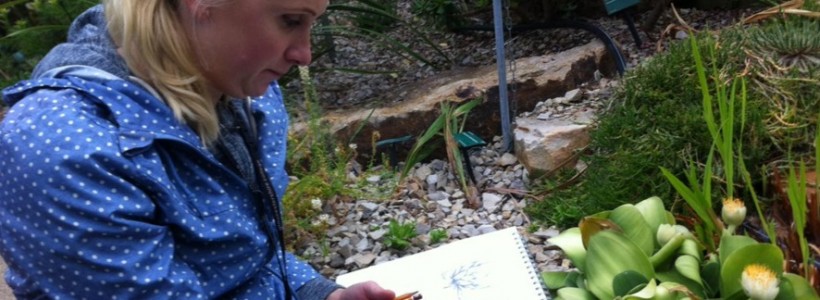 Mature student sitting in the Great Glasshouse sketching one of the plants