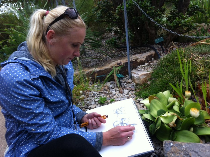 Mature student sitting in the Great Glasshouse sketching one of the plants